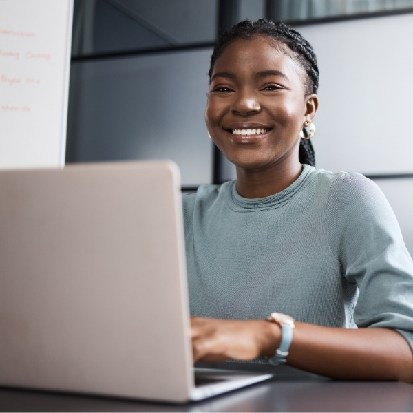 Online Master of Arts in Communication, Digital Media, and AI student working on laptop